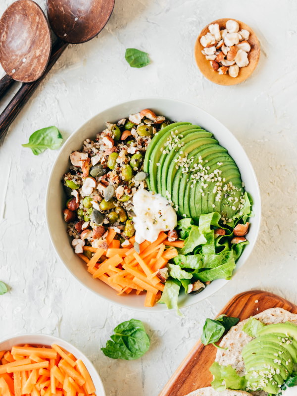 Delicious vegan bowl with quinoa, avocado, edamame, carrots, hazelnuts and pumpkin seeds