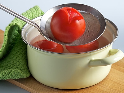 Tomaten in kochendes Wasser legen
