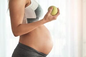Schwangere mit Apfel