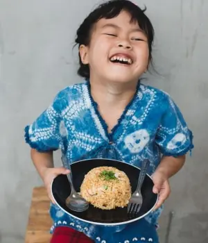 Kind mit Reisteller