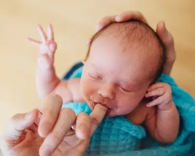 Baby saugt an Finger