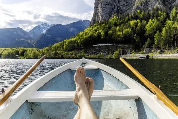 Füße im Boot vor Bergen