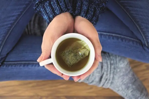 Haende-halten-Tasse-gruenen-Tee