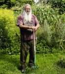 Wolf-Dieter Storl steht mit Spatengabel im Garten