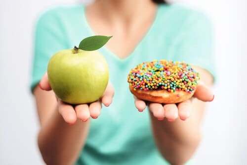 Diabetes_Frau mit Apfel und Donut