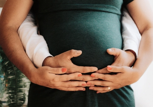 Schwangerschaft_Frau und Mann haben Hände vor Schwangerem Bauch